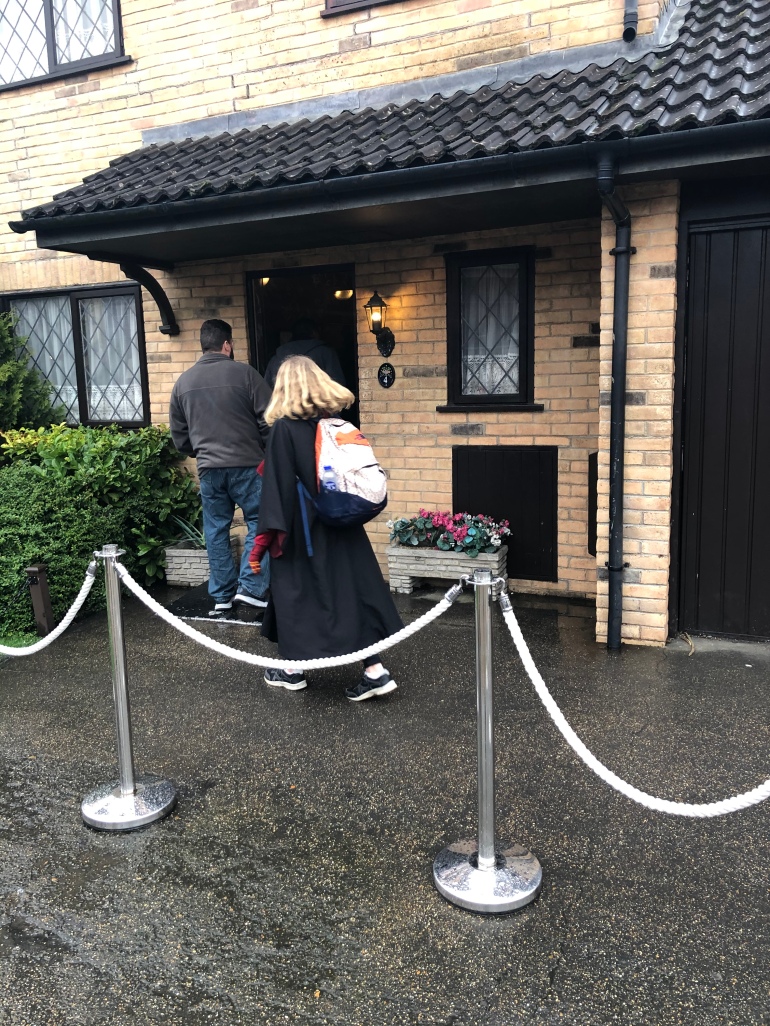 En man och en flicka på väg in i Harrys hus på Private Drive